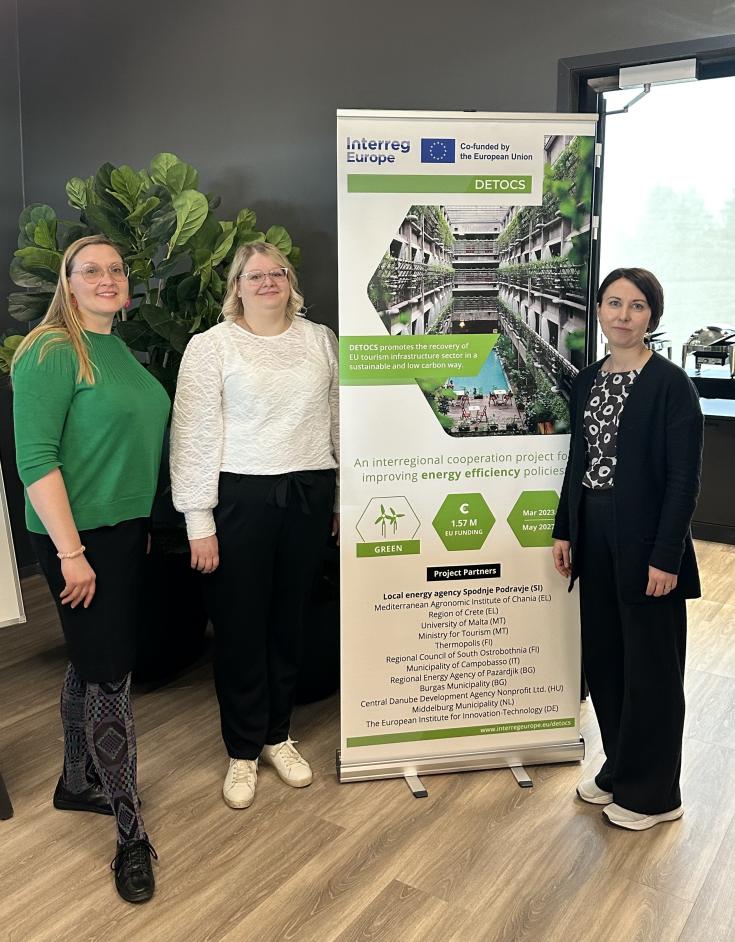 Workshop was organized by the Regional Council of South Ostrobothnia and Thermopolis together with external expert Elisa Kraatari Three white women stand next to a banner stand