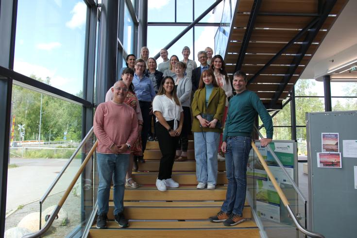 A group of people smiling and standing in a staircase.