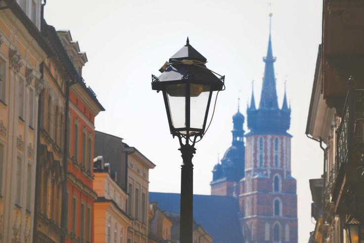Lamp in historical center of Krakow, surrounded by buildings Lamp in Krakow