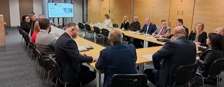 Photo of the meeting room with participants listening to presentations