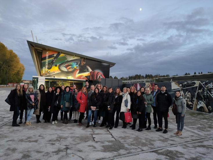 A group of people posing in front of a mural