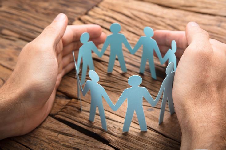 NEAR project image hands encircling and supporting paper people standing in a circle holding hands