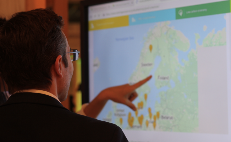 People looking at map on screen People looking at map on screen