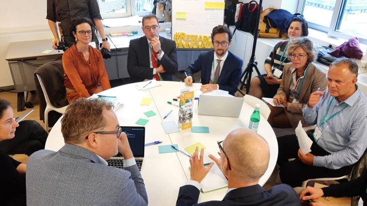 People sitting and discussing around a round table People sitting and discussing around a round table