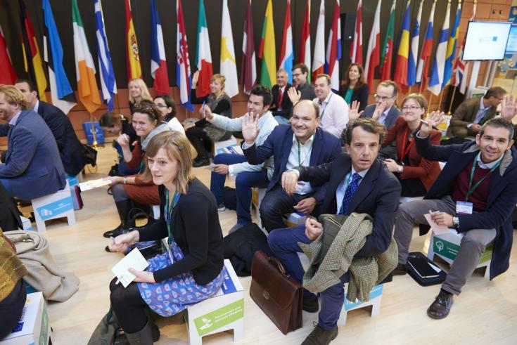 People sitting and raising hands