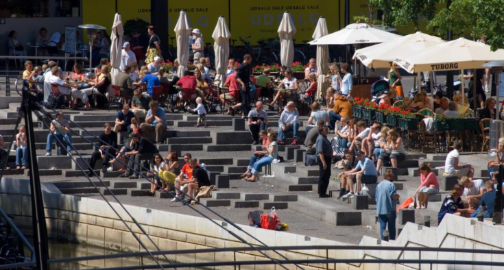 People sitting on steps near water