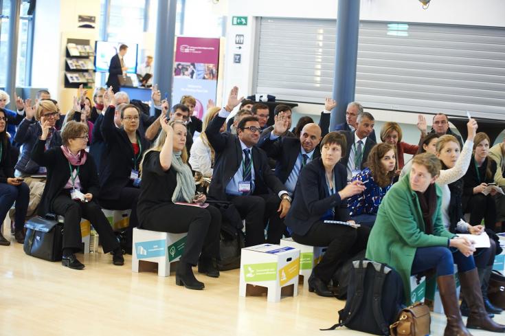 People sitting on stools during event People sitting on stools during event