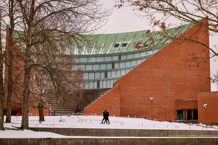 People walking in snow in front of building