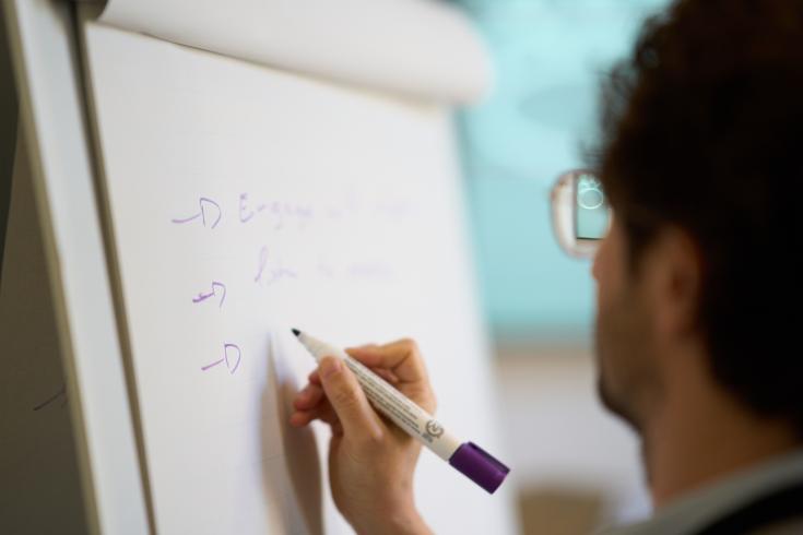Person writing on a board