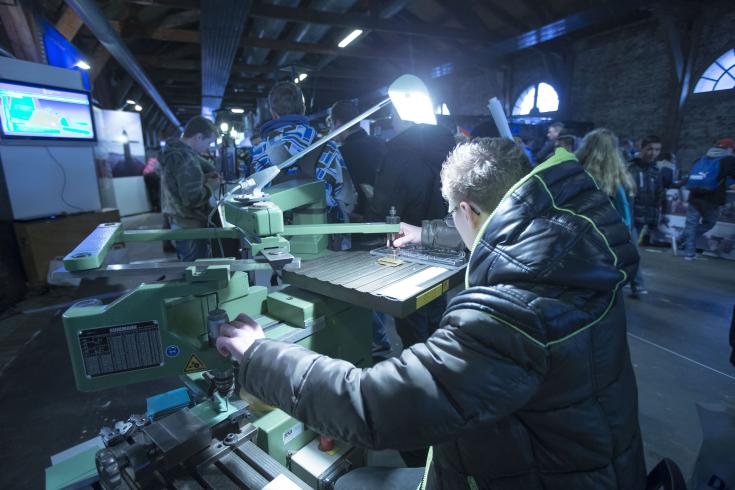 A variety of people using various machines to innovate and create.