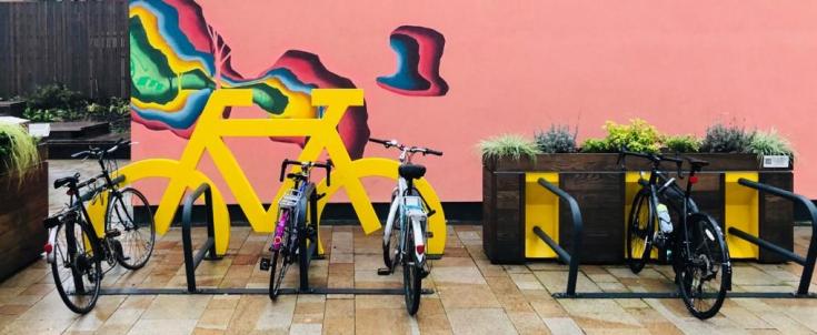 Row of bike in front of a colorful wall 