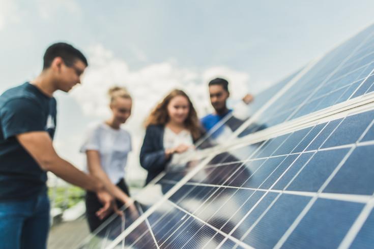 Group of people around a solar panel