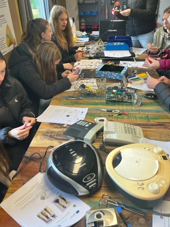 Participants of the in-person action can be seen sitting at a table, exchanging perspectives.