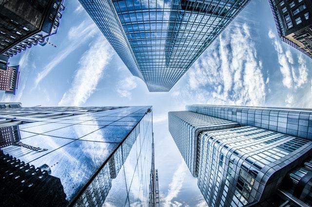 View up high rise buildings with reflecting glass