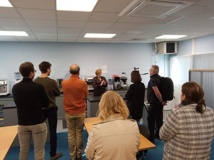people stand in a room where a guide explains the barista room in the training centre