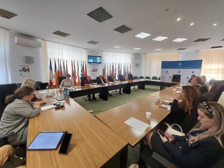 Participants at the MDLPA stakeholder meeting discussing inter-municipal cooperation and conclusions from the SHARING project's second interregional event. Flags of EU countries are displayed in the background.