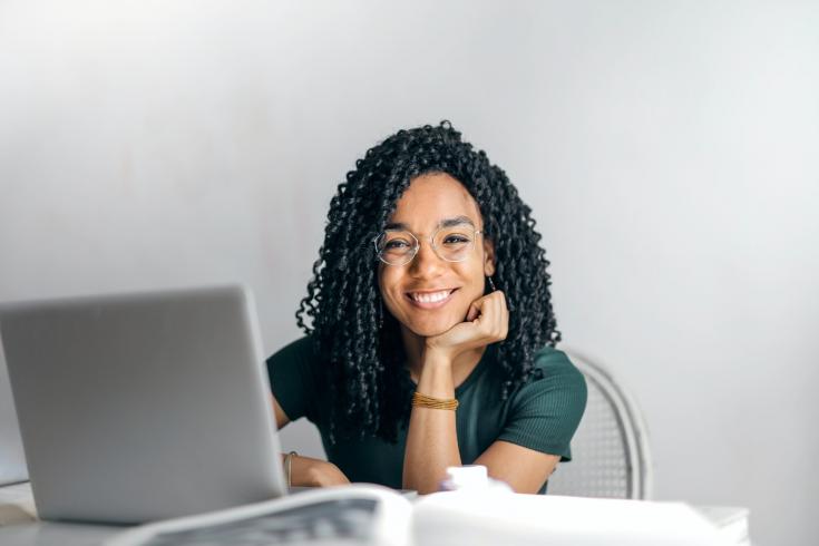 Woman smiling from behind a computer