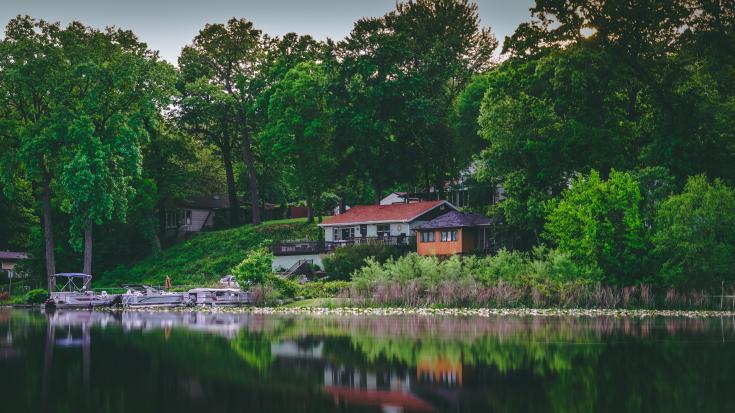 a house close to water with green scenery