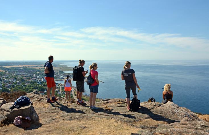 Persons hiking and looking at the sea from a cliff on a dunny day