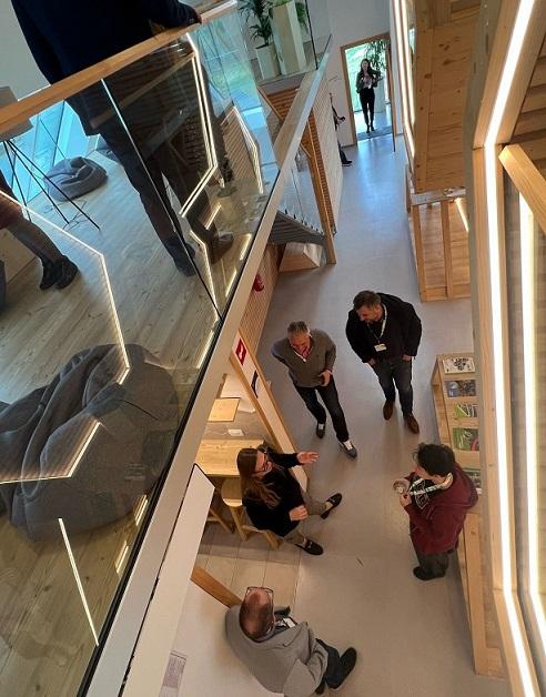 A small group of people talking informally, viewed from a balcony above