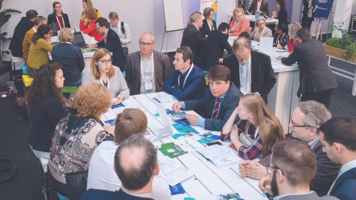 group of people discussing around a table at an event