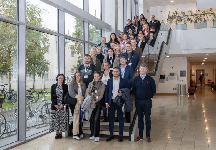 About 30 people posing on a staircase during a study visit