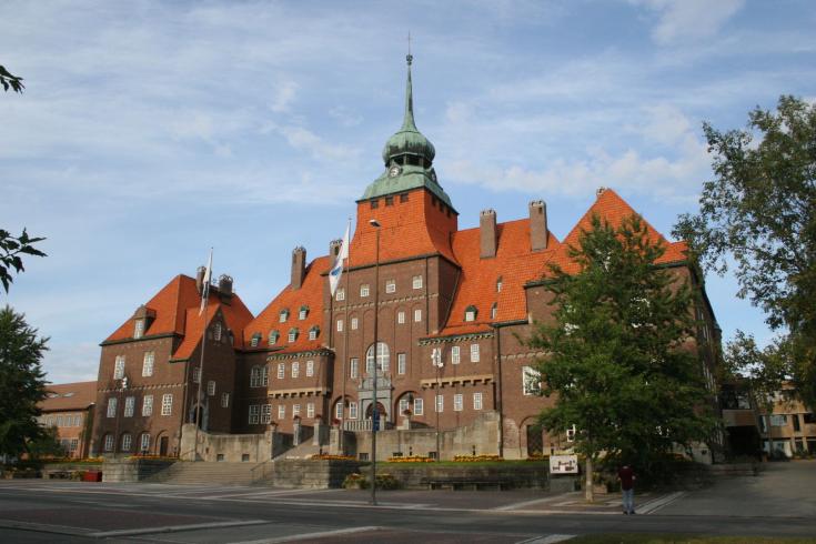 a large building of earth colored brick and a red tiled roof with a dome