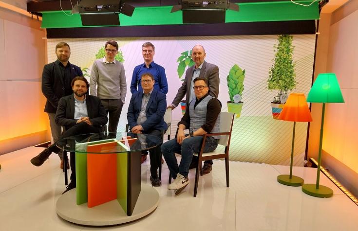 Seven people smiling for a picture, taken with colorful furniture 