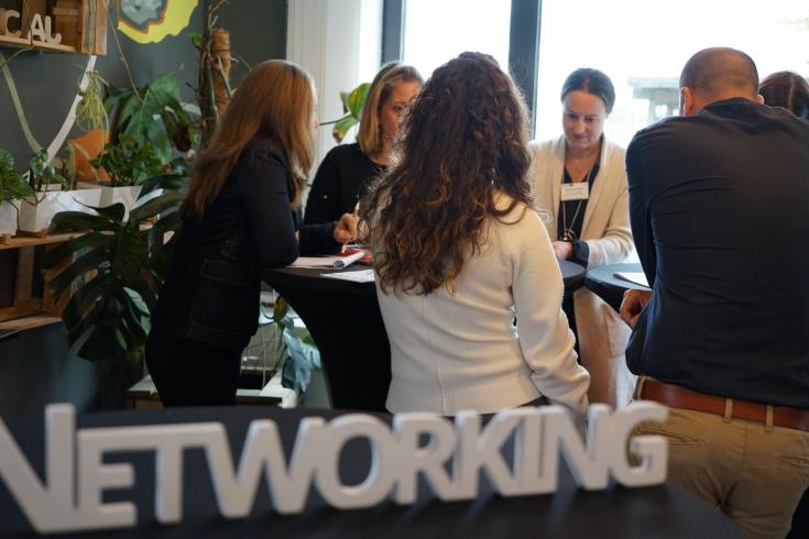 Group of people in circle with networking hashtag in front
