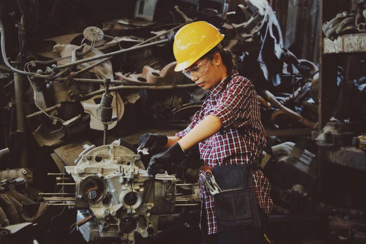 An image of a woman skillfully working with heavy machinery. 