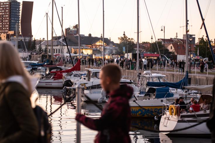 Port with numerous boats and people strolling