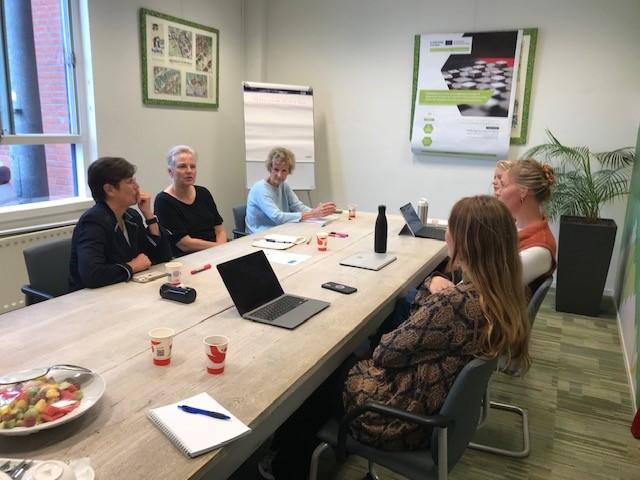 5 Women sitting in a table discussing strategies do reduce waste