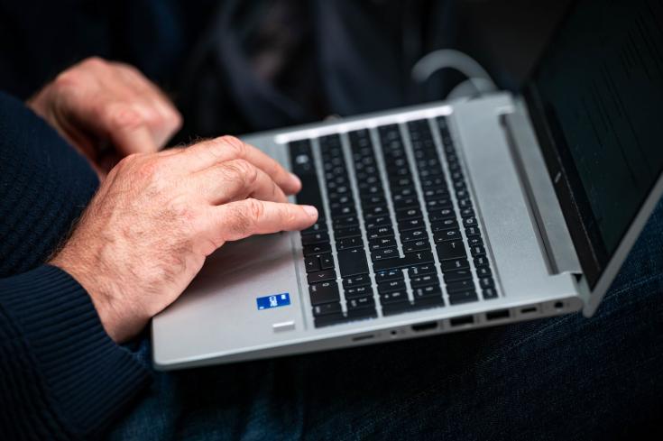 Man sitting down and using laptop.