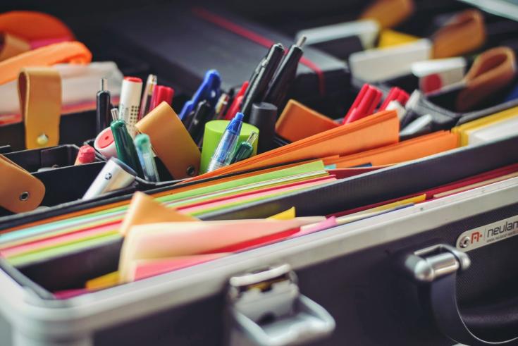 assorted pens, sticky notes, colorful papers to use for brainstorming and note taking in an organiser case
