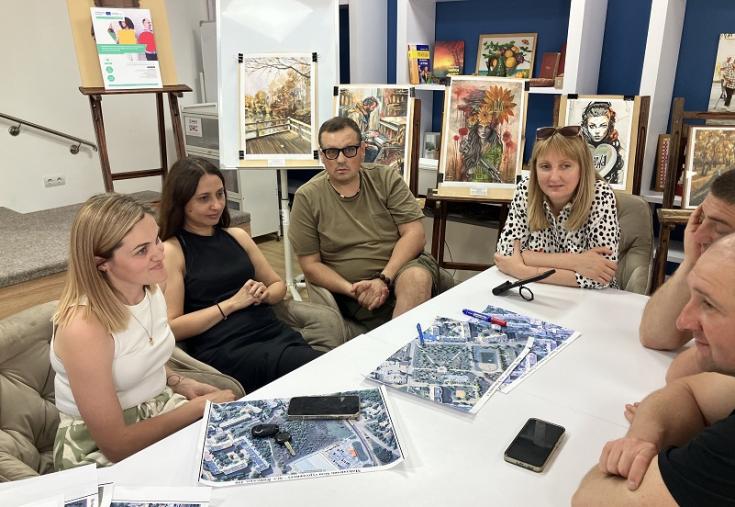 People sitting around a table with aerial photographs of the town