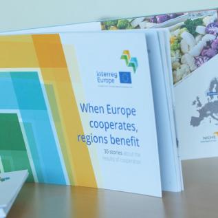 Publication entitled 'When Europe cooperates, regions benefit' placed upon a table with hashtag Europe cooperates behind it