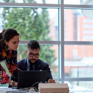 Two people working on a laptop Two people working on a laptop