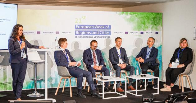 panel of speakers on a stage with a moderator