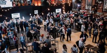 Wide shot of the main hall in the venue with people networking during Europe, let's cooperate! 2025 event at Stara Zajezdnia, Kraków