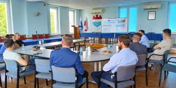Representatives of the lead partner together with project stakeholders seating around a table 