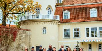 Group of people posing in front of a castle, in Cēsis, Latvia. 