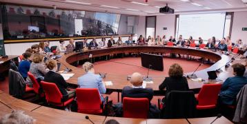 People around a round table, listening to the conference