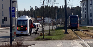 Passenger is getting off from an autonomous shuttle bus at the Hervantajärvi tram stop