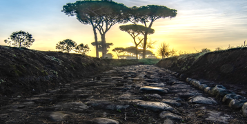 View of a sunset from the Ancient Appian Way, with some trees in the background