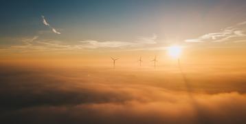 A group of windmills in the sky above the clouds