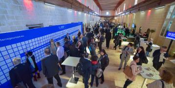 Crowd of people in a hall way networking at an event.