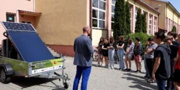 The picture shows children standing in front of the school where the photovoltaic panel is presented