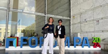 Two people standing in front of a sign for Forum PA 2024