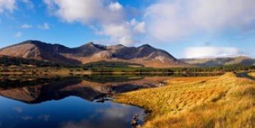 Connemara National Park with mountains and a reflective lake under a blue sky