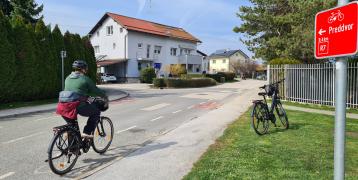 The image shows a signpoast on a cycling route that is part of the Gorenjska cycling network.